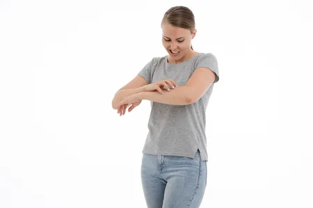 Femme qui se gratte le bras à cause de démangeaisons
