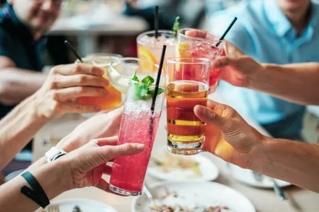 Friends toasting with colorful cocktails