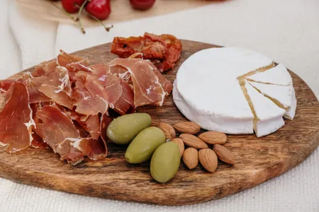 Board of cured ham, cheese, olives and almonds